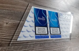 Brend reklamni uzorak slikan pod uglom na drvenoj podlozi, prikazujući teksturu sočiva.